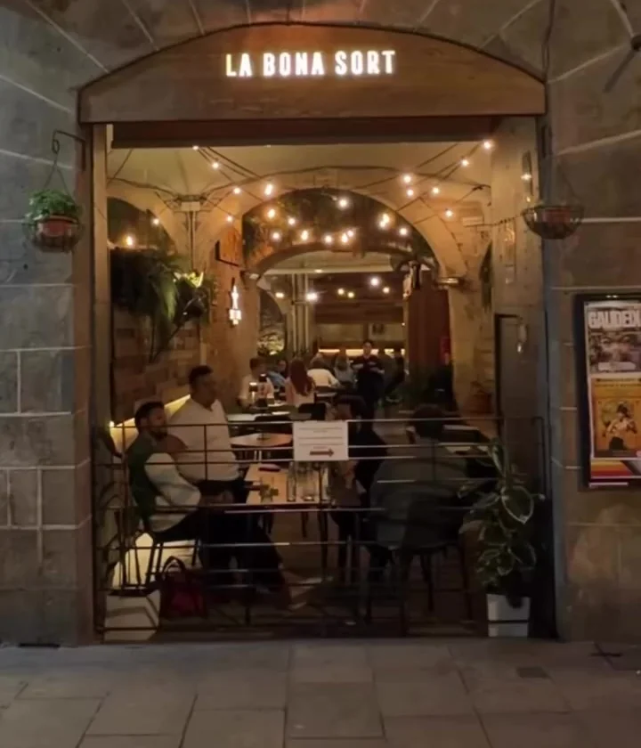 The entrance to La Bona Sort on Carrer dels Carders, with the lit passage at the back