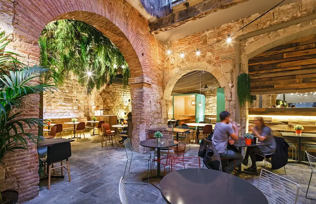 The terrace arches, with hanging plants and tables in use